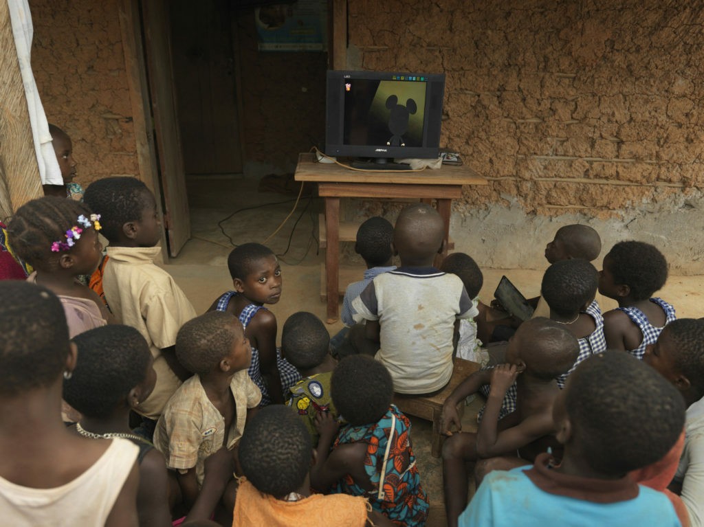 I bambini figli dei lavoratori di CAYAT, in Costa D'Avorio attorno alla televisione acquistata con i soldi del Premio. a Baoulekro, un villaggio locale di 300 persone. ©Peter Caton